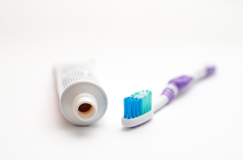 On,A,White,Background,Lies,A,Toothpaste,And,Brush,For